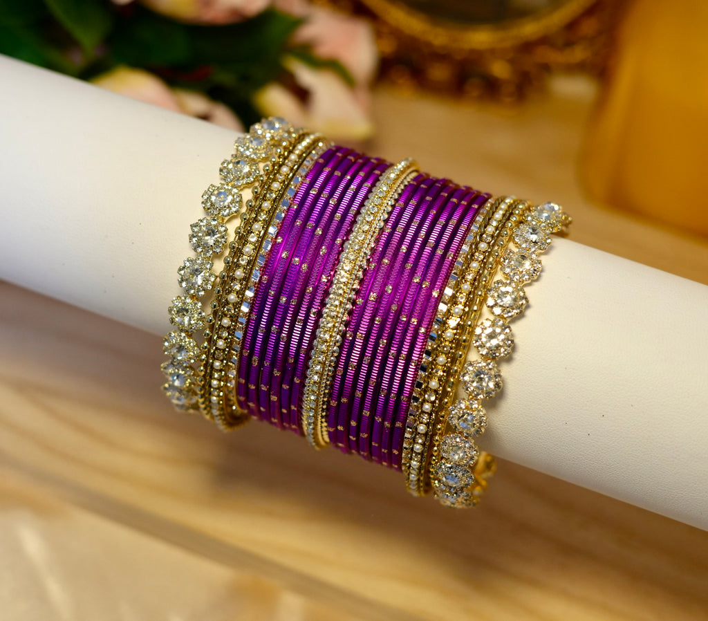 Purple bracelet with gold and silver accents on a white surface